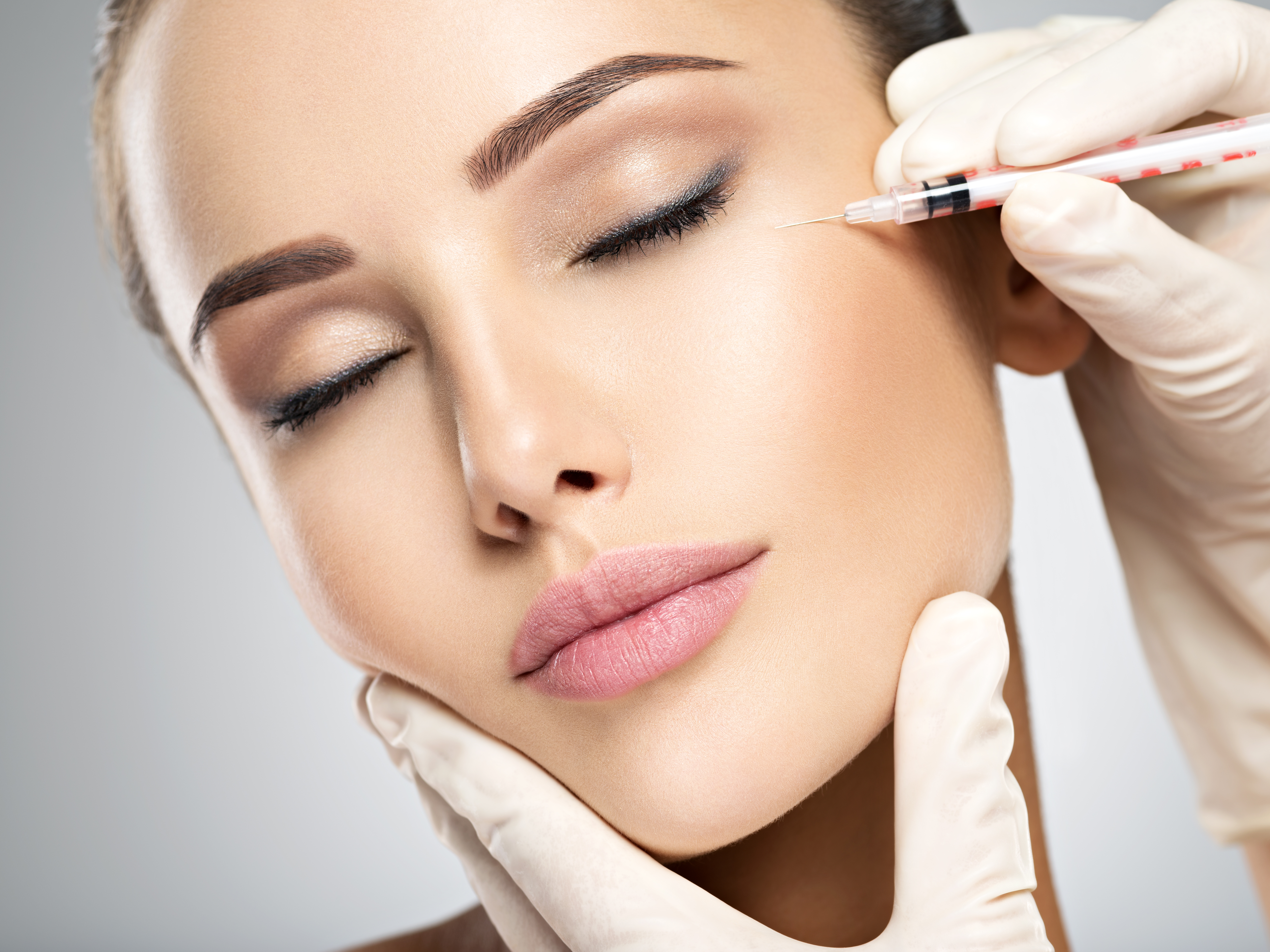 Woman getting cosmetic injection of botox near eyes